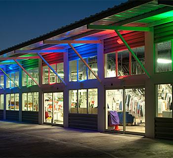 The Rainbow Cleaners exterior is equipped with computerized LEDs that project lights of different colors up the face of the building and under the white canopy. / Photo by Rainbow Cleaners
