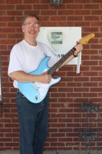 Austin's Music owner Kenneth Lacy with the G&L guitar that will be raffled.