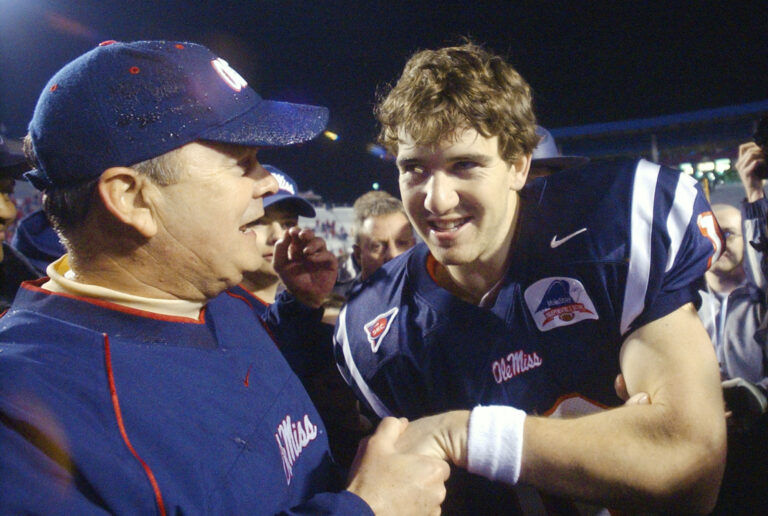 Mississippi coach David Cutcliffe, left, congratulates quarterback Eli Manning following Mississippi's 27-23 win over Nebraska in the Independence Bowl in Shreveport, La., Dec. 27, 2002.
