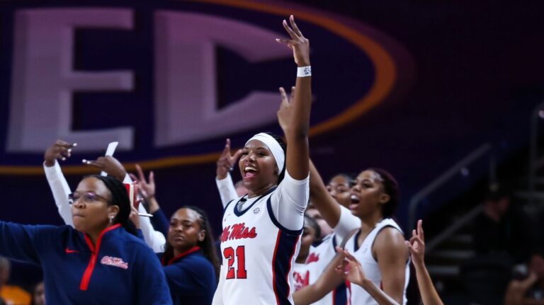 Ole Miss women's basketball coaches and players celebrate a three-pointer in the first half of an SEC Tournament first-round game. | Ole Miss Athletics