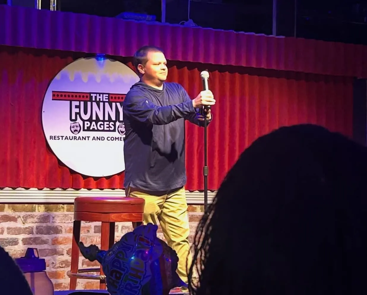 Walt Karr performs stand-up comedy onstage during a live show in Oxford, Mississippi.