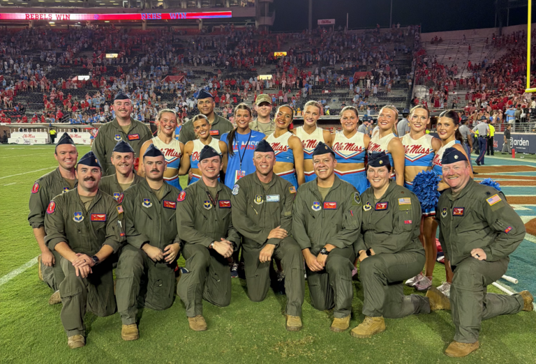 U.S. Air Force aircrew members pose with Ole Miss cheerleaders on the field at Vaught-Hemingway Stadium following the C-17 flyover.
