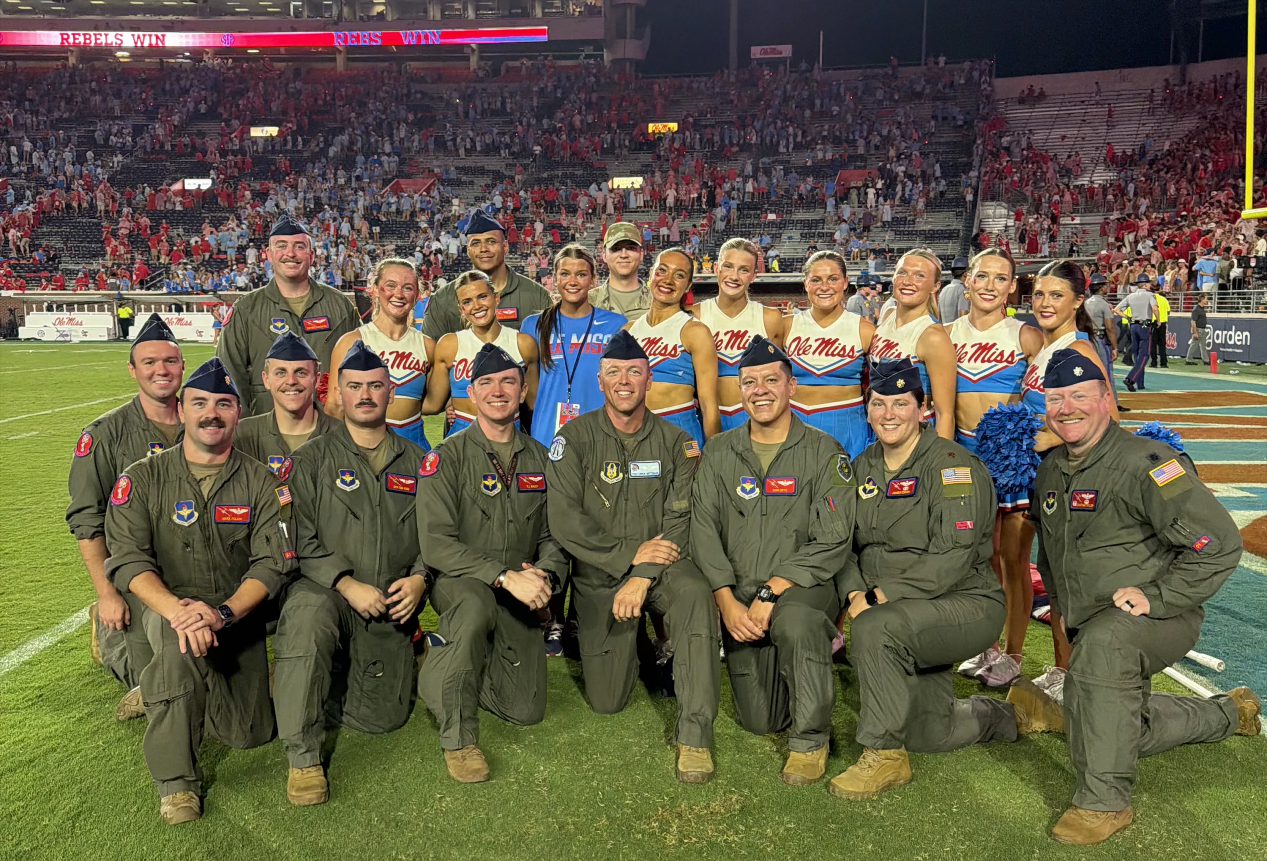U.S. Air Force aircrew members pose with Ole Miss cheerleaders on the field at Vaught-Hemingway Stadium following the C-17 flyover.