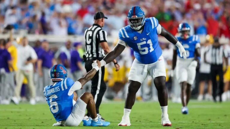 Ole Miss offensive lineman Delano Townsend helps up quarterback Trinidad Chambliss against LSU. | Ole Miss Athletics
