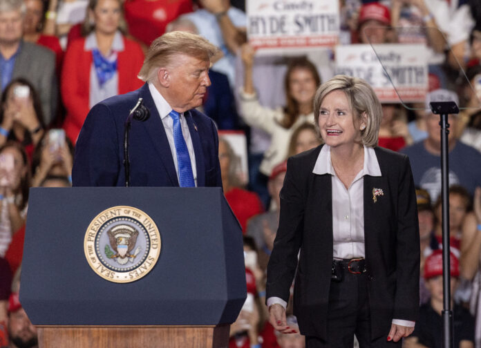 President Donald Trump invites Sen. Cindy Hyde-Smith on stage at a Corinth, Mississippi campaign rally.